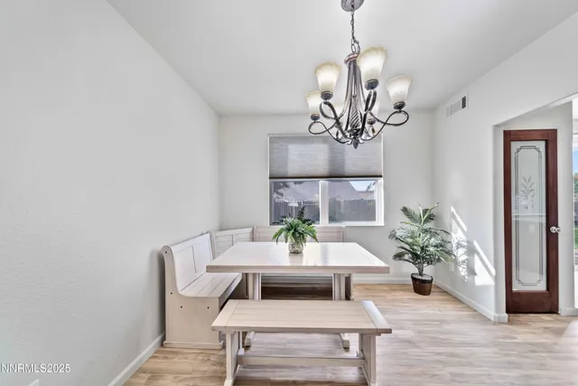 a view of a dining room with furniture wooden floor and a chandelier