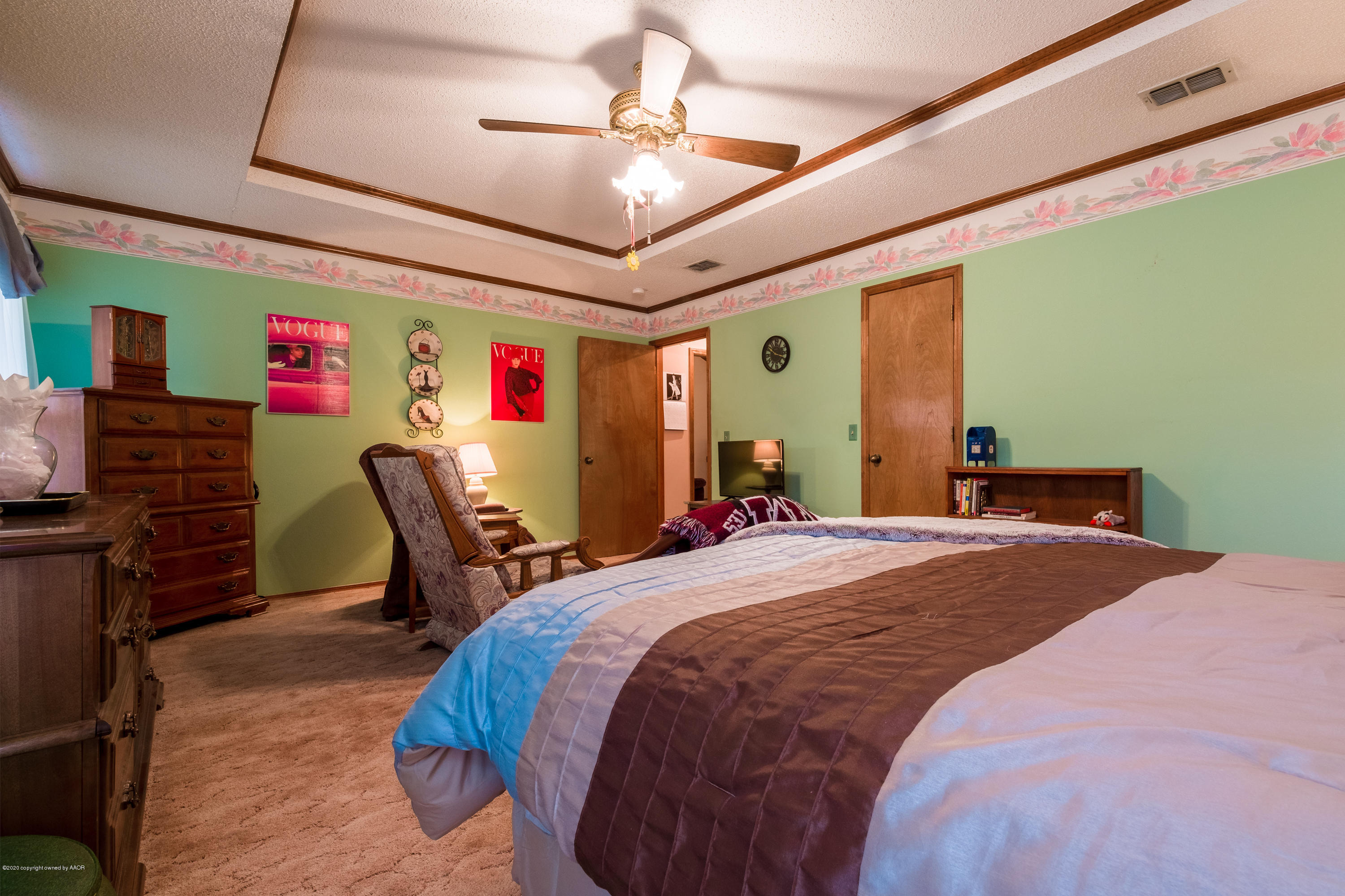 5718 South Fannin Street Amarillo, TX 79110 - Photo 19 of 31 a bedroom with a bed dresser and a chandelier