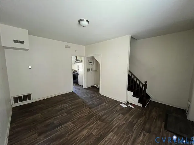 a view of an empty room with wooden floor and closet