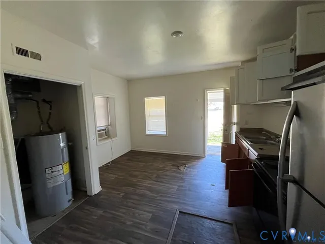 a view of a kitchen with refrigerator and wooden floor