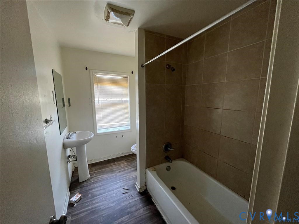 703-705 Harding Street Petersburg, VA 23803 - Photo 9 of 14 a bathroom with a tub a sink and wooden floor