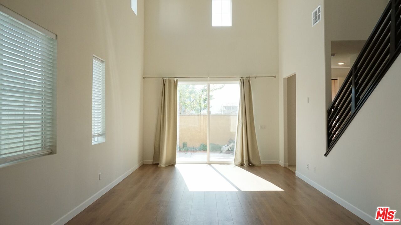 8564 Exposition Street Chino, CA 91708 - Photo 13 of 29 a view of wooden floor and windows in an empty room