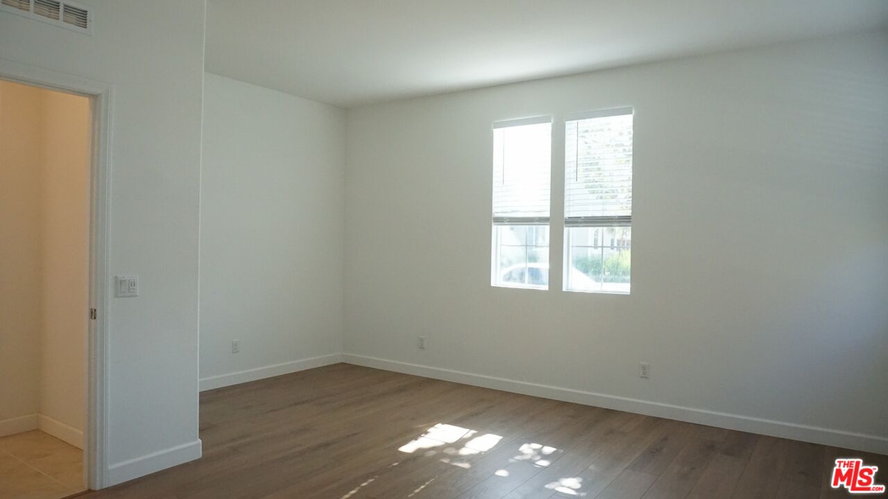 8564 Exposition Street Chino, CA 91708 - Photo 18 of 29 an empty room with wooden floor and windows