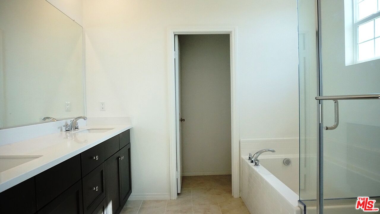8564 Exposition Street Chino, CA 91708 - Photo 25 of 29 a bathroom with a tub sink and mirror