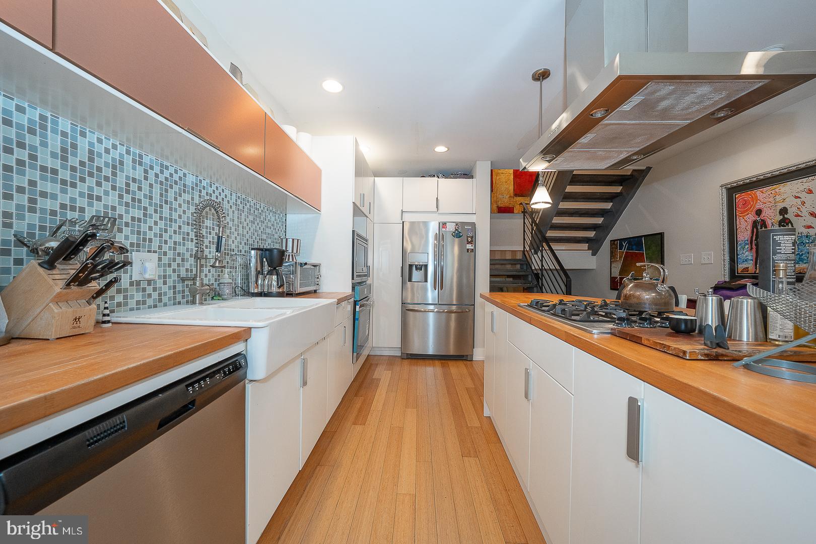 715 Shirley Street, Unit A Philadelphia, PA 19130 - Photo 7 of 24 a large white kitchen with stainless steel appliances granite countertop lots of counter top space and wooden floor