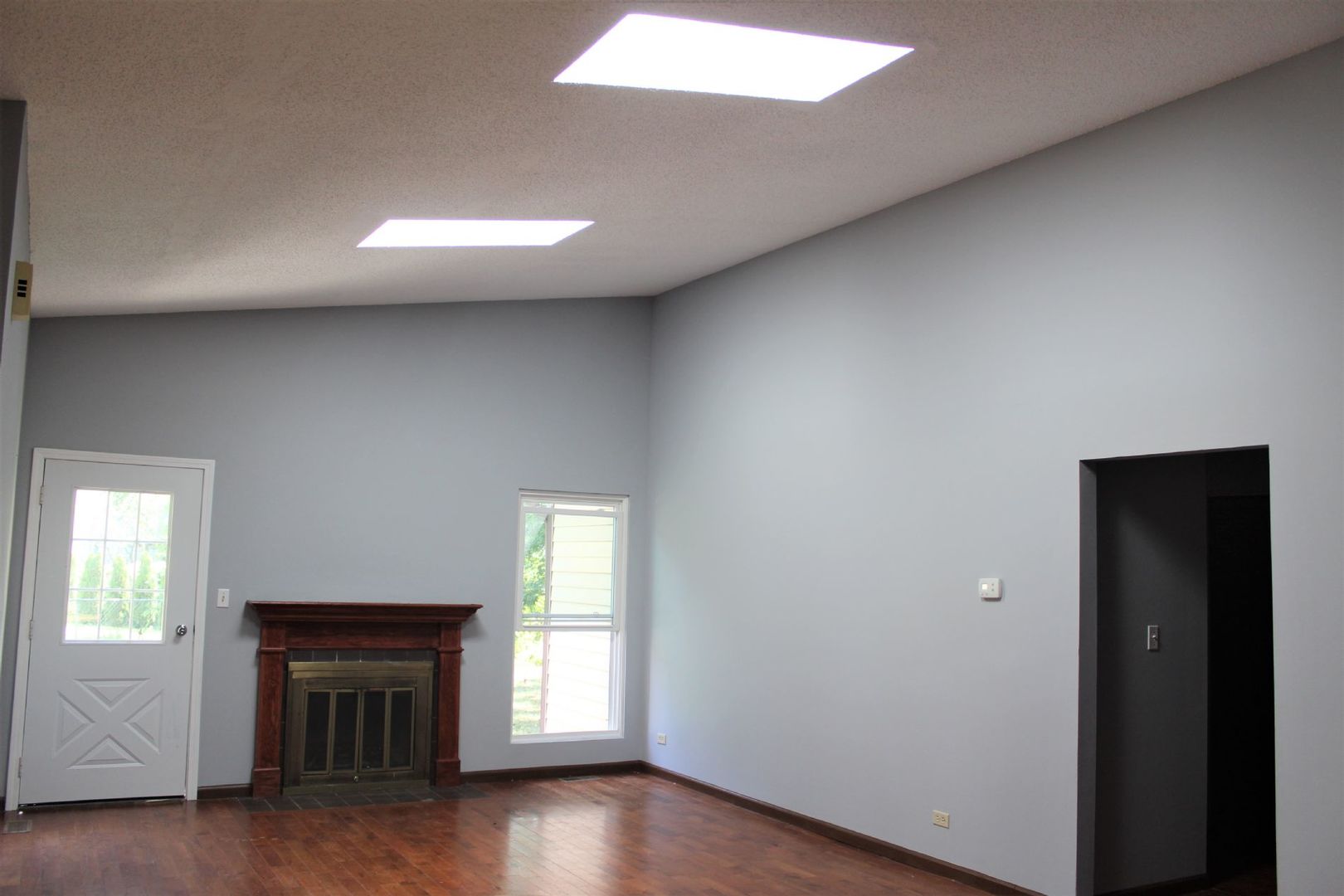 1391 Rennet Drive Naperville, IL 60565 - Photo 9 of 21 an empty room with wooden floor fireplace and windows