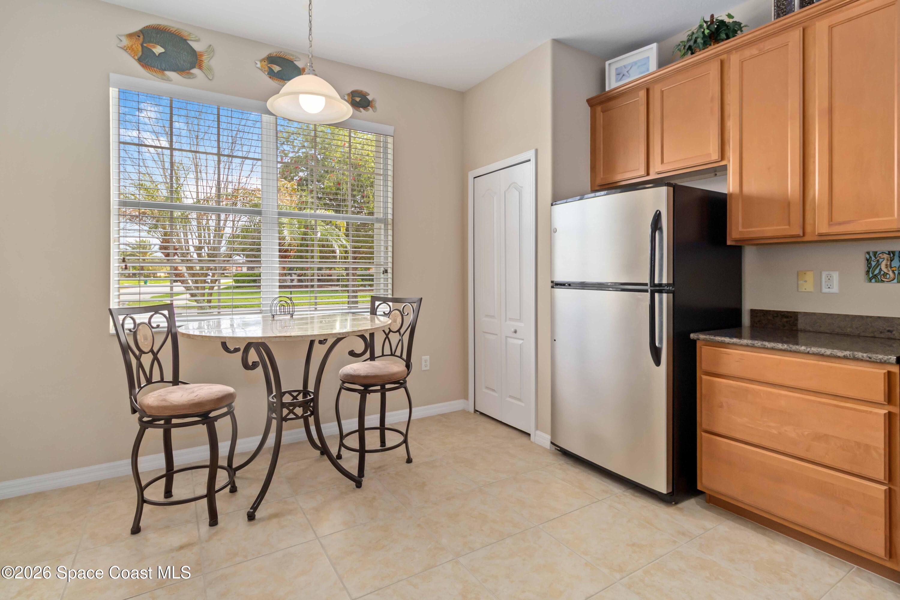 6604 Pico Street Melbourne, FL 32940 - Photo 11 of 36 a kitchen with refrigerator cabinets dining table and chairs
