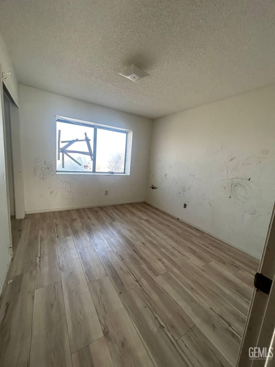 Undisclosed Address Tehachapi, CA 93561 - Photo 8 of 10 an empty room with wooden floor and windows