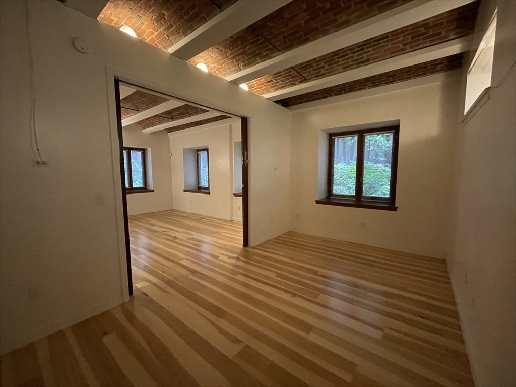 61 Prince Street, Unit 1C Boston, MA 02113 - Photo 12 of 26 a view of an empty room with wooden floor and a window