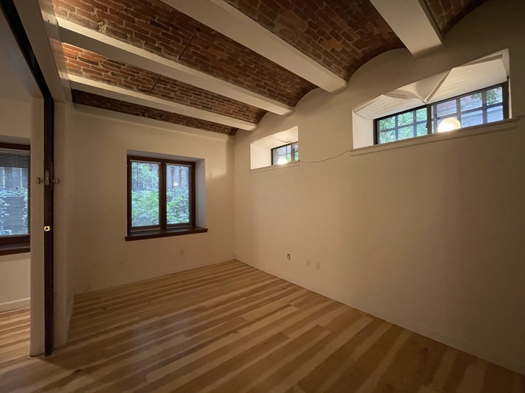 61 Prince Street, Unit 1C Boston, MA 02113 - Photo 13 of 26 a view of a hallway with wooden floor and a window