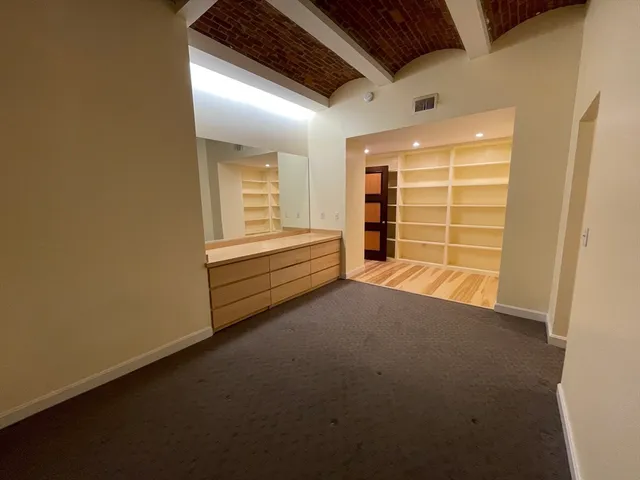 a view of an empty room with a fireplace and a window