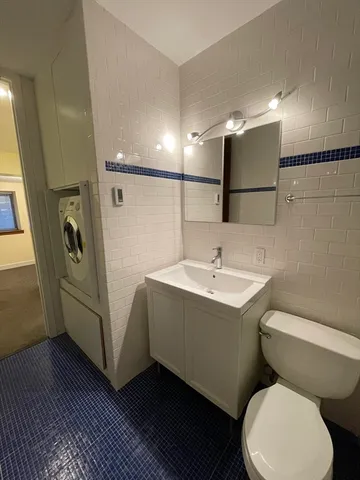 a bathroom with a toilet sink and mirror