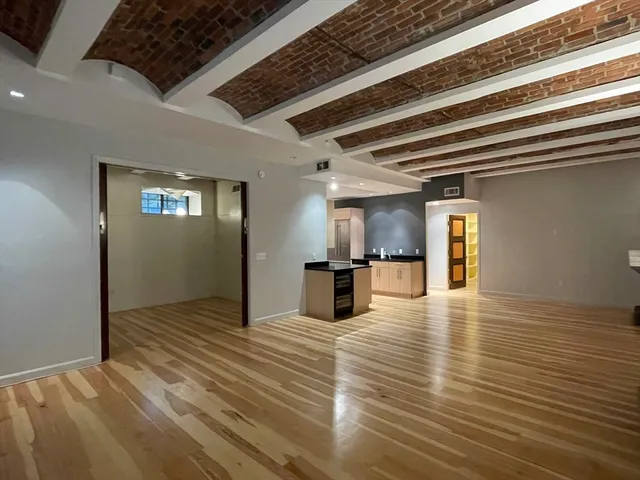 a view of a livingroom with a flesh screen tv and wooden floor