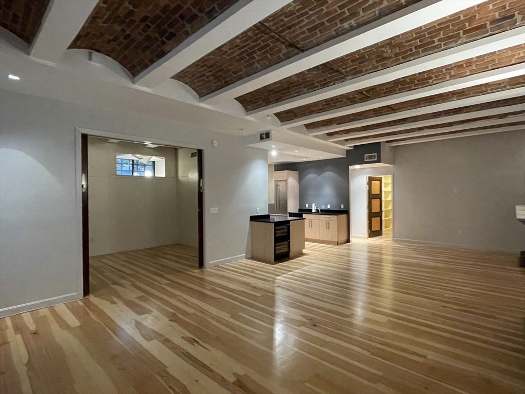 61 Prince Street, Unit 1C Boston, MA 02113 - Photo 6 of 26 a view of a livingroom with a flesh screen tv and wooden floor