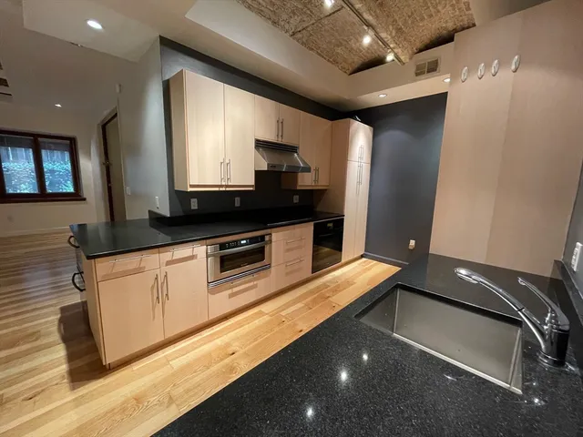 a kitchen with stainless steel appliances granite countertop a sink a stove and a refrigerator