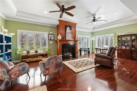 a living room with furniture a fireplace and a ceiling fan