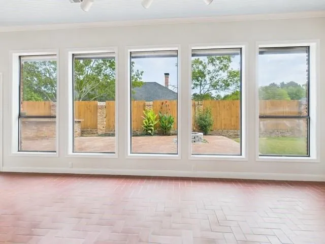 an empty room with wooden floor and outdoor view