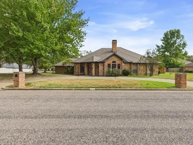 a front view of a house with a yard and trees