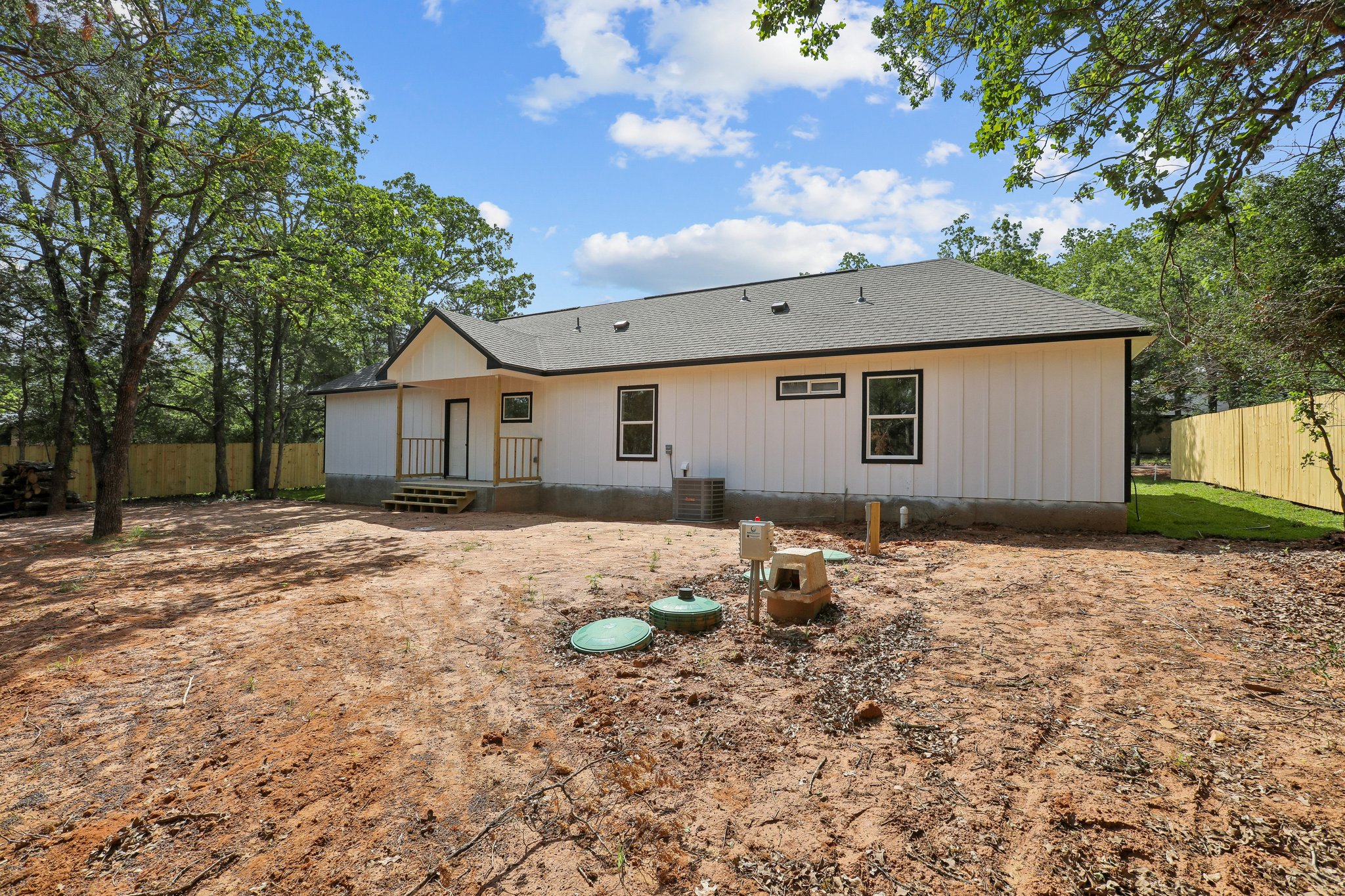 210 Flint Ridge Street Bastrop, TX 78602 - Photo 37 of 40 a backyard of a house with table and chairs under a large tree