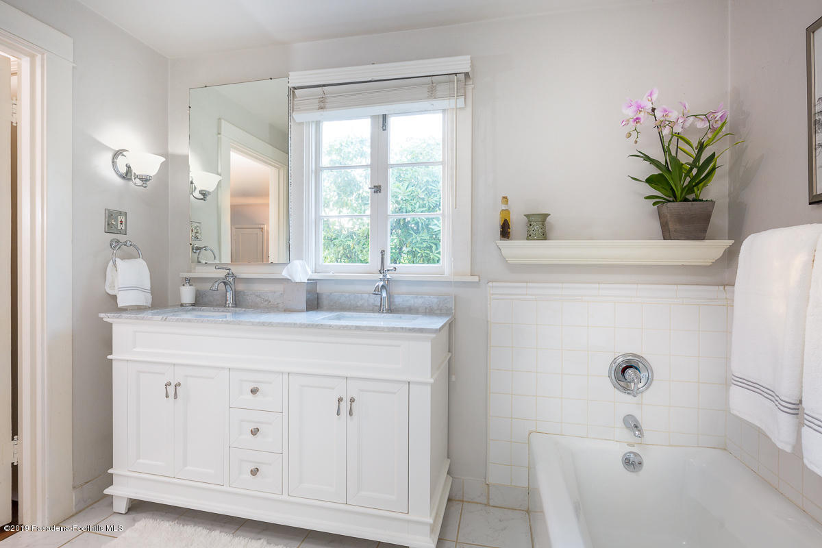155 Club Road Pasadena, CA 91105 - Photo 37 of 50 a bathroom with a granite countertop sink a large mirror a bathtub and a window