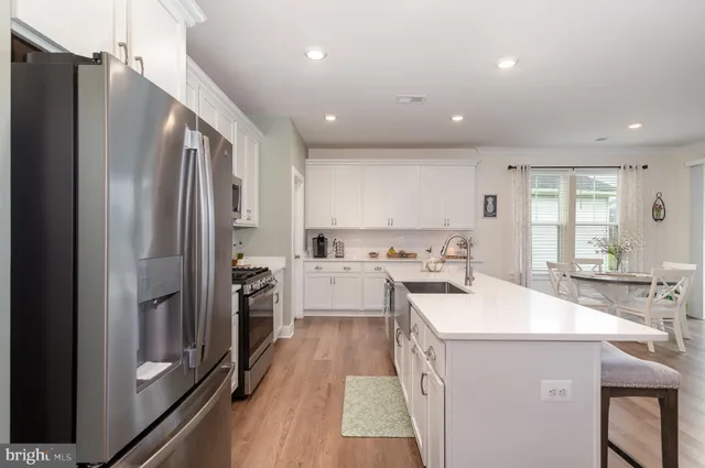 a kitchen with a sink appliances and wooden floor