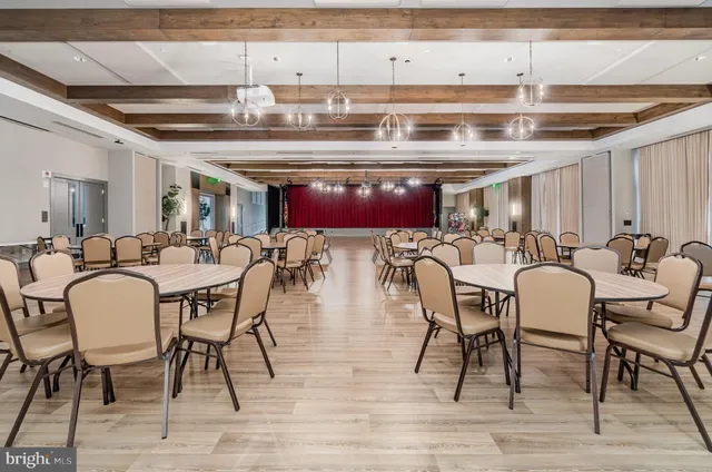 a view of a dining hall with furniture and a kitchen view