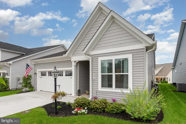 a front view of a house with a garden and plants