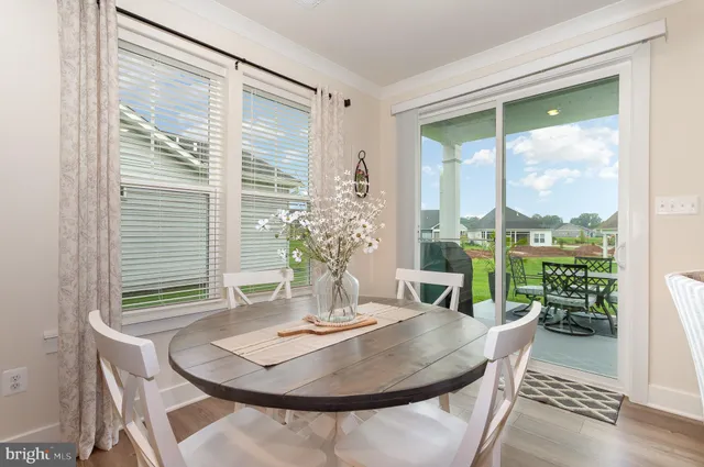 a kitchen with stainless steel appliances granite countertop a table chairs refrigerator and a stove