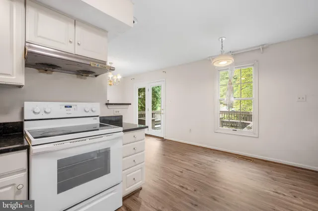 a kitchen with a stove oven and white cabinets
