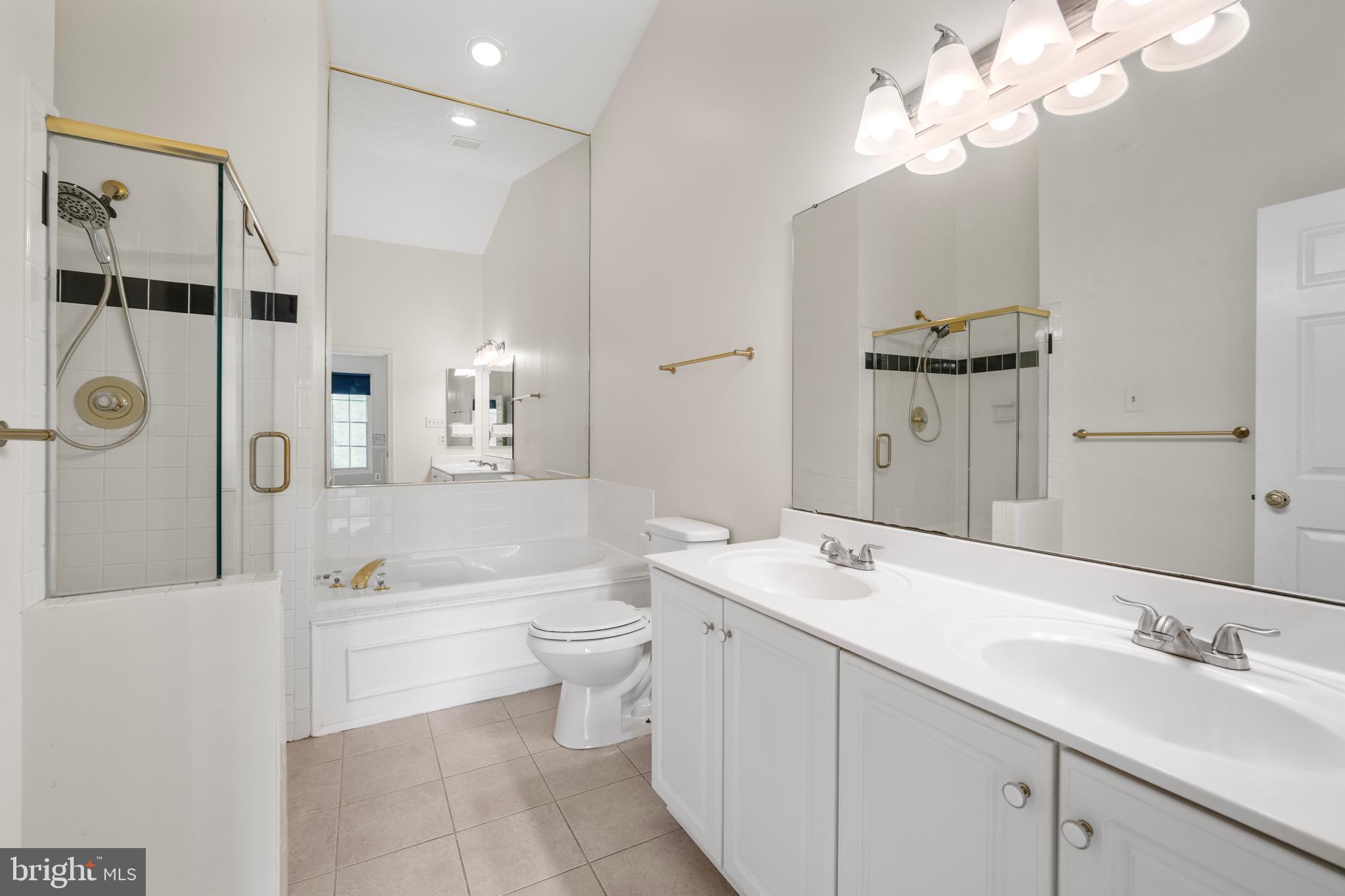 5522 April Journey, Unit 11 Columbia, MD 21044 - Photo 20 of 34 a bathroom with a double vanity sink a toilet a mirror and shower