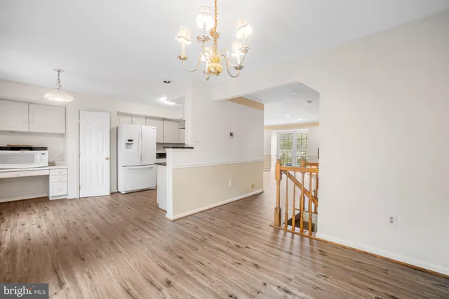 a view of a kitchen with a sink and dishwasher a refrigerator with wooden floor