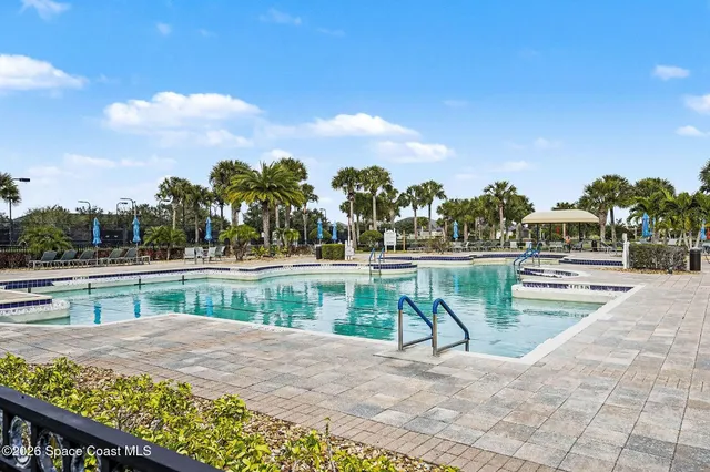 a view of a swimming pool with a bench and trees
