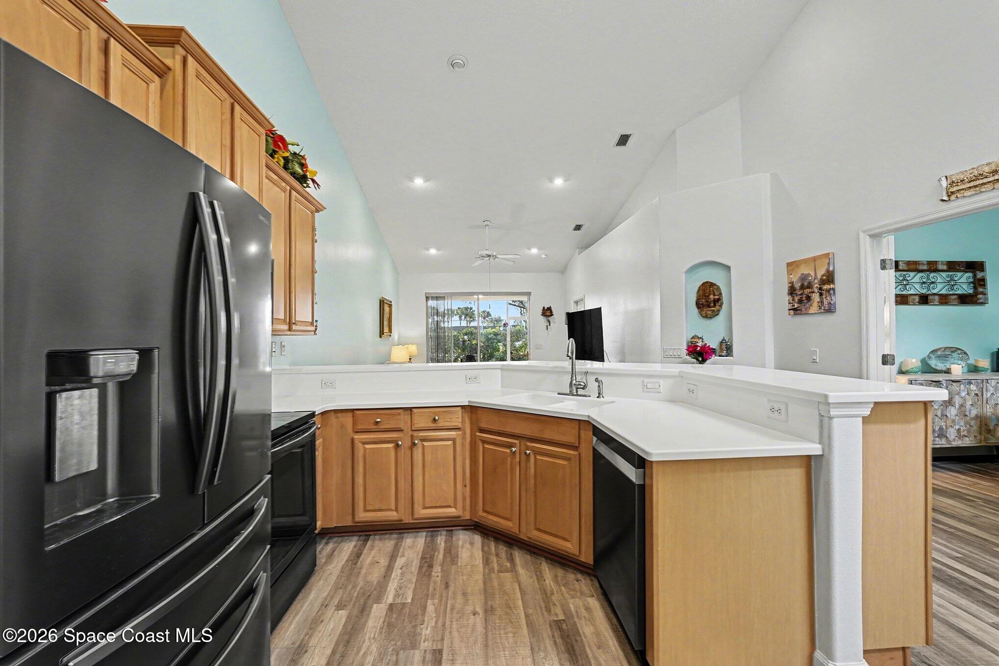 3051 Le Conte Street Melbourne, FL 32940 - Photo 4 of 32 a kitchen with stainless steel appliances granite countertop a sink and dishwasher a refrigerator with wooden floor