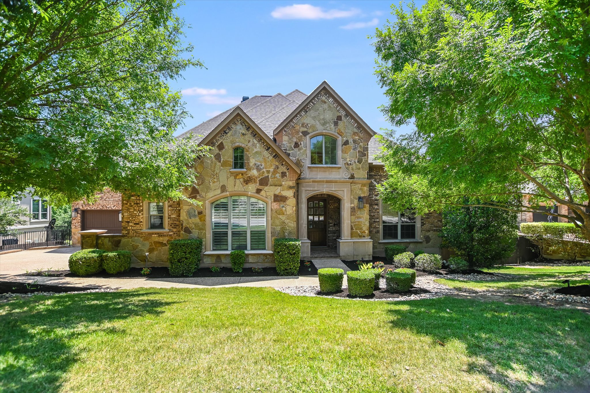 1016 SANTALUZ Path Austin, TX 78732 - Photo 3 of 40 a front view of a house with garden and trees
