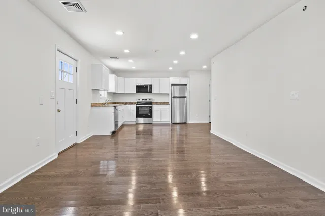 a view of kitchen with granite countertop cabinets and wooden floor