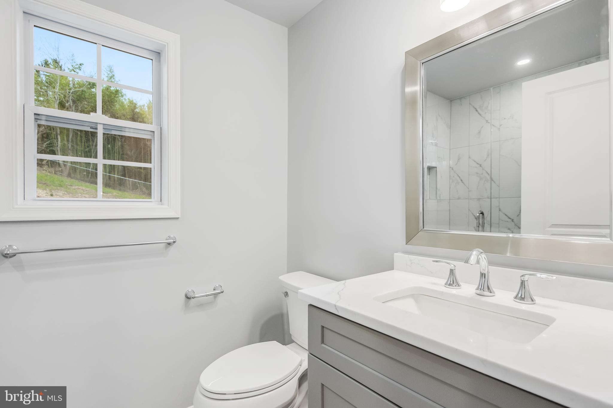 4010 Oaklawn Road Fort Washington, MD 20744 - Photo 18 of 37 a bathroom with a granite countertop sink toilet a mirror and a window