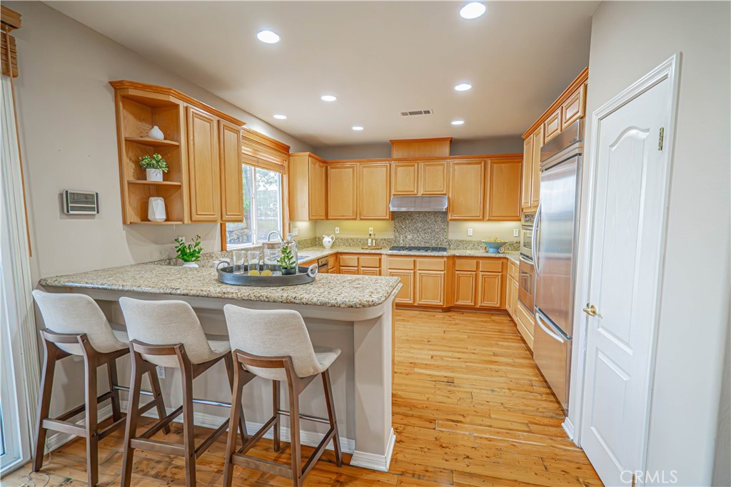 28419 Hidden Hills Drive Saugus, CA 91390 - Photo 13 of 60 a kitchen with granite countertop white cabinets and stainless steel appliances