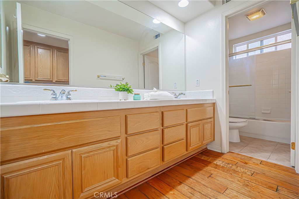 28419 Hidden Hills Drive Saugus, CA 91390 - Photo 50 of 60 a bathroom with a granite countertop sink mirror vanity and toilet