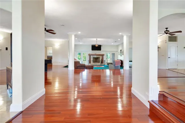 a view of a hallway with wooden floor and a living room