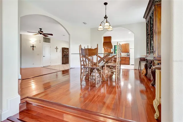 a view of a dining room and livingroom with furniture wooden floor a chandelier