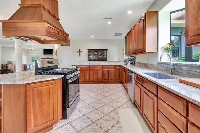 a large kitchen with stainless steel appliances granite countertop a sink and a stove
