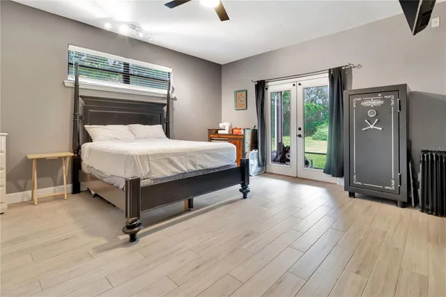 a bedroom with a bed a table and painting on the wall