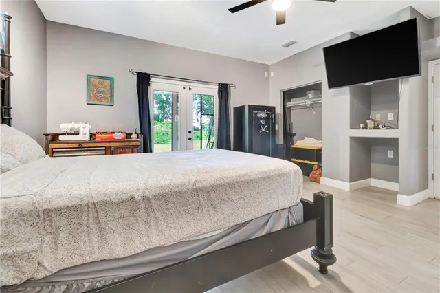 a bedroom with a bed and a flat tv screen on dresser