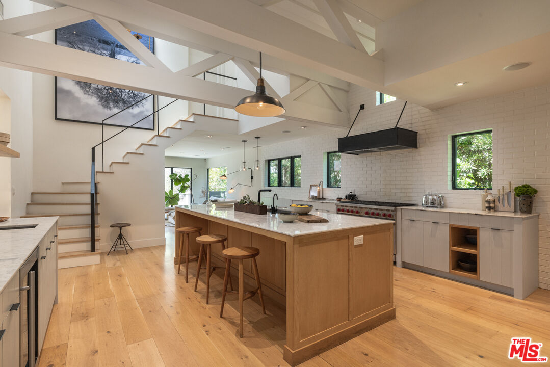 226 South Rimpau Boulevard Los Angeles, CA 90004 - Photo 14 of 43 a kitchen with stainless steel appliances granite countertop a sink a stove and a wooden floors