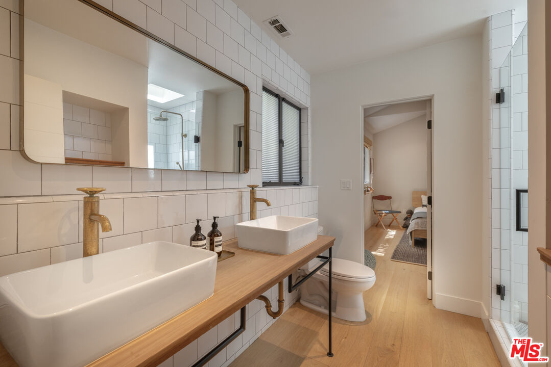226 South Rimpau Boulevard Los Angeles, CA 90004 - Photo 23 of 43 a bathroom with a bathtub a sink and a mirror