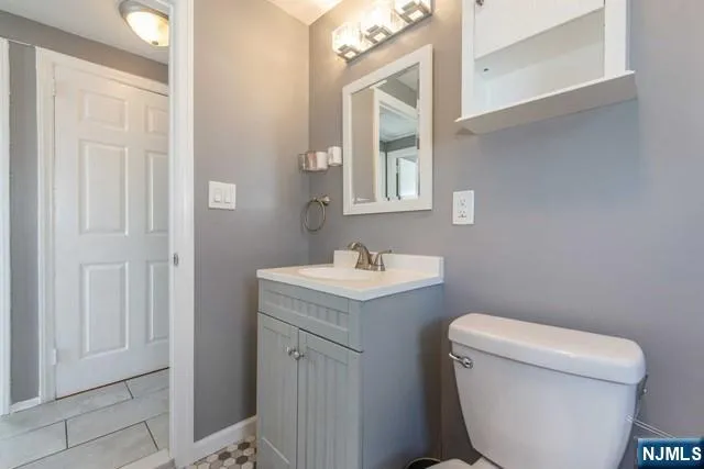 a bathroom with a toilet a sink and mirror