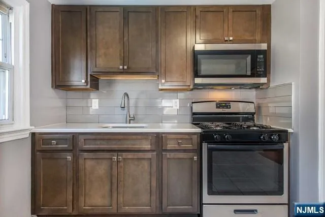 a kitchen with granite countertop a stove and a microwave