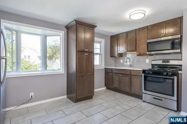 a kitchen with granite countertop a refrigerator and a stove top oven