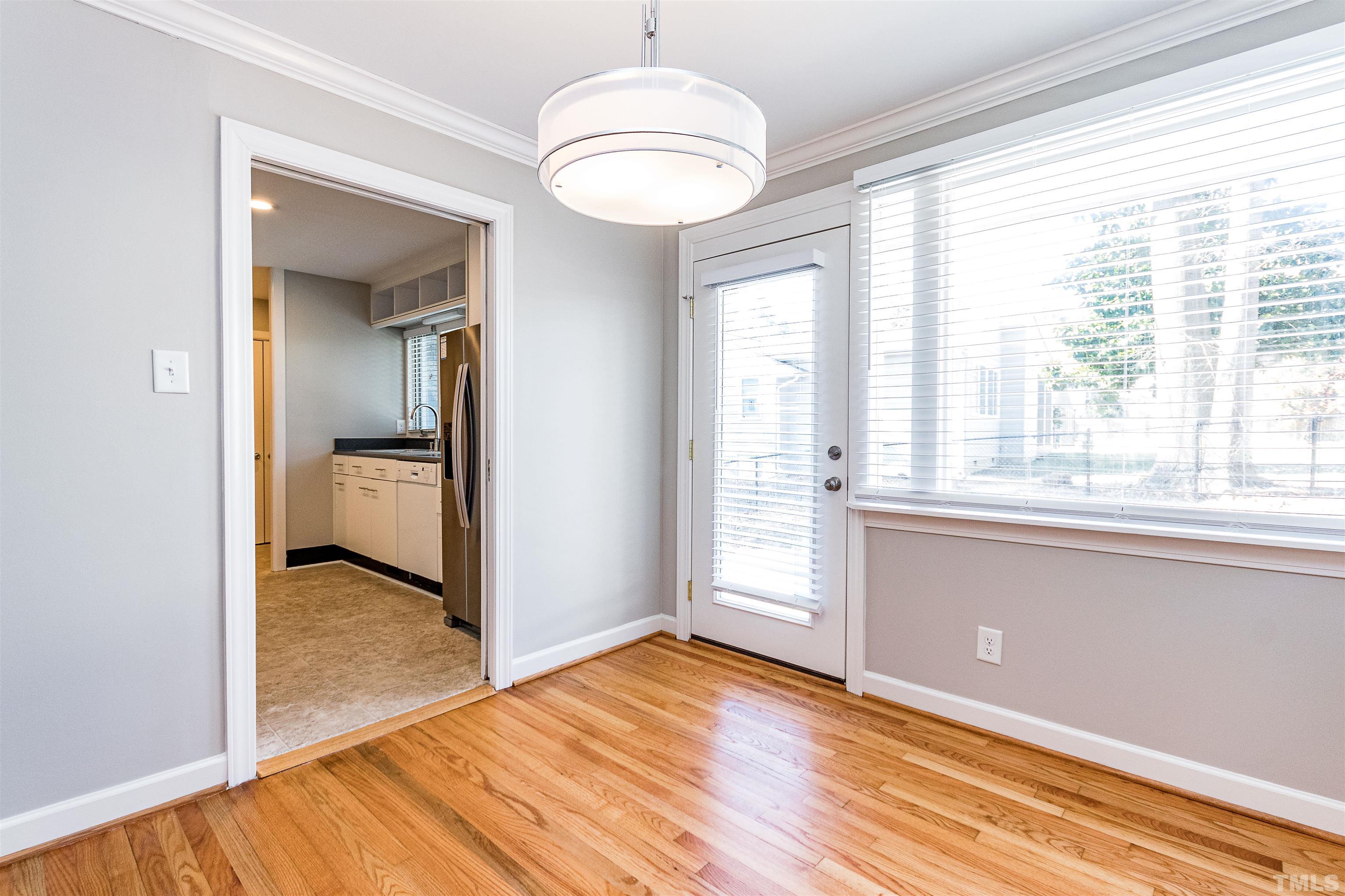 3412 Bradley Place Raleigh, NC 27607 - Photo 11 of 28 a view of an empty room with a window and wooden floor