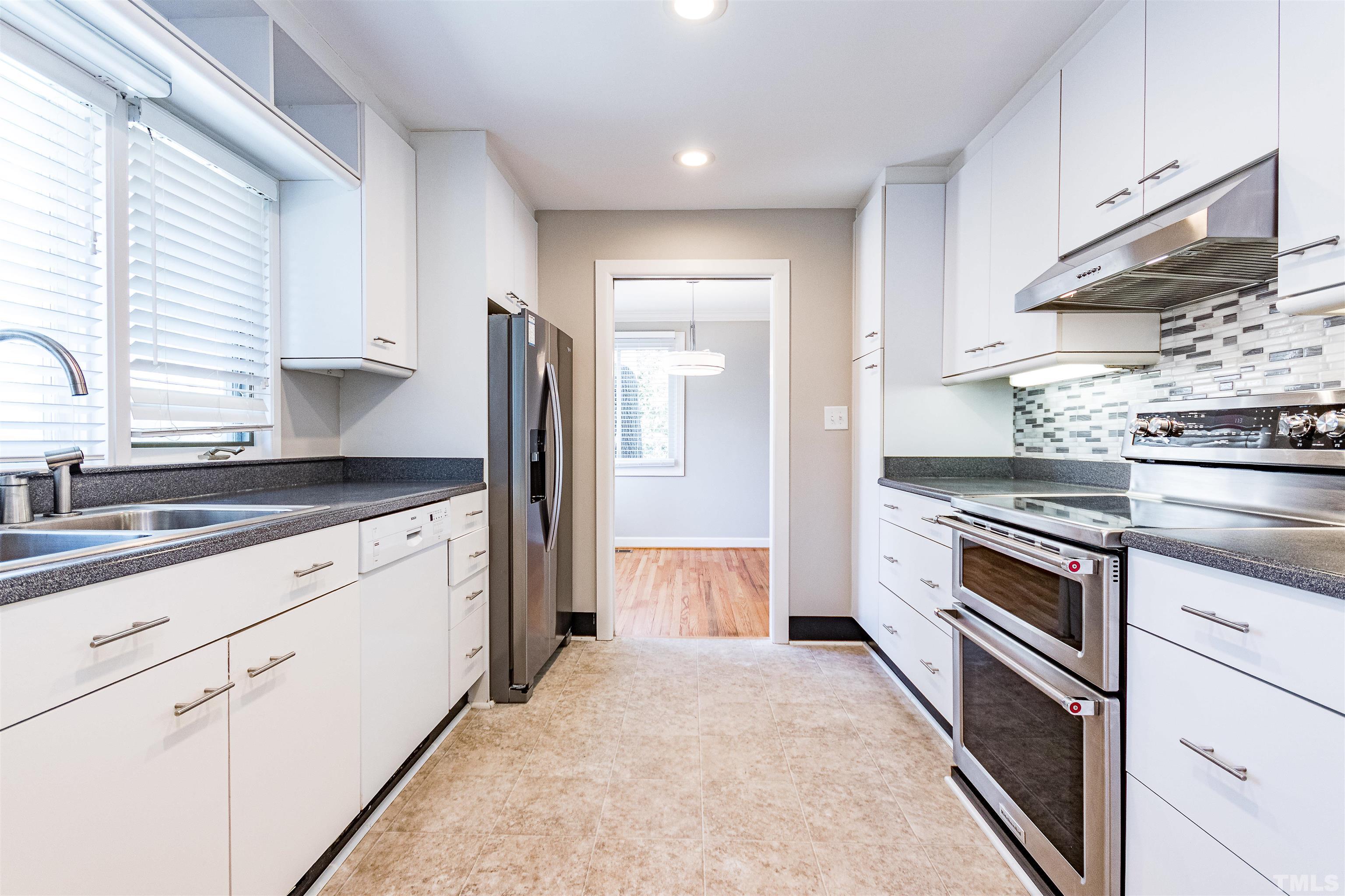3412 Bradley Place Raleigh, NC 27607 - Photo 15 of 28 a kitchen with granite countertop white cabinets and stainless steel appliances